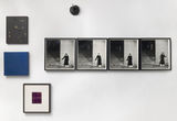 Thumb_sequence-of-4-images-of-a-person-standing-waiting-for-people-to-come-down-the-stairs_-3-paintings-_one-of-monochrome-blue-and-another-of-monochrome-grey-with-a-face-forming_-and-half-a-stone-apple-hanging-from-the-wall-above-all-of-that