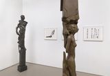 Thumb_two-statues_-one-brown-and-one-greyish-black-resembling-humans-and-3-paintings-behind-it